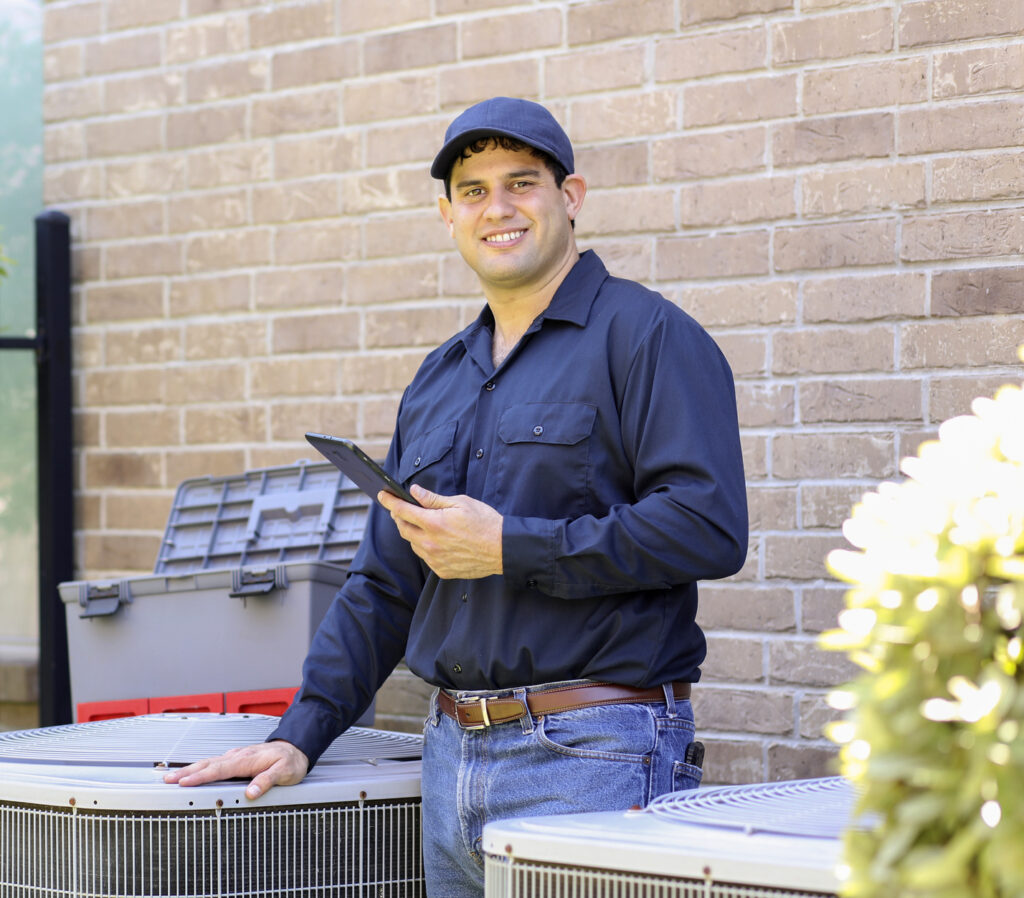 Latin Descent, Blue Collar Air Conditioner Repairman At Work.